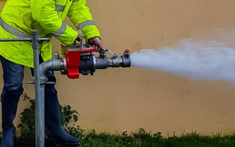 A worker performing a fire hydrant testing