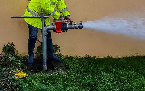 A worker performing a fire hydrant testing - water management